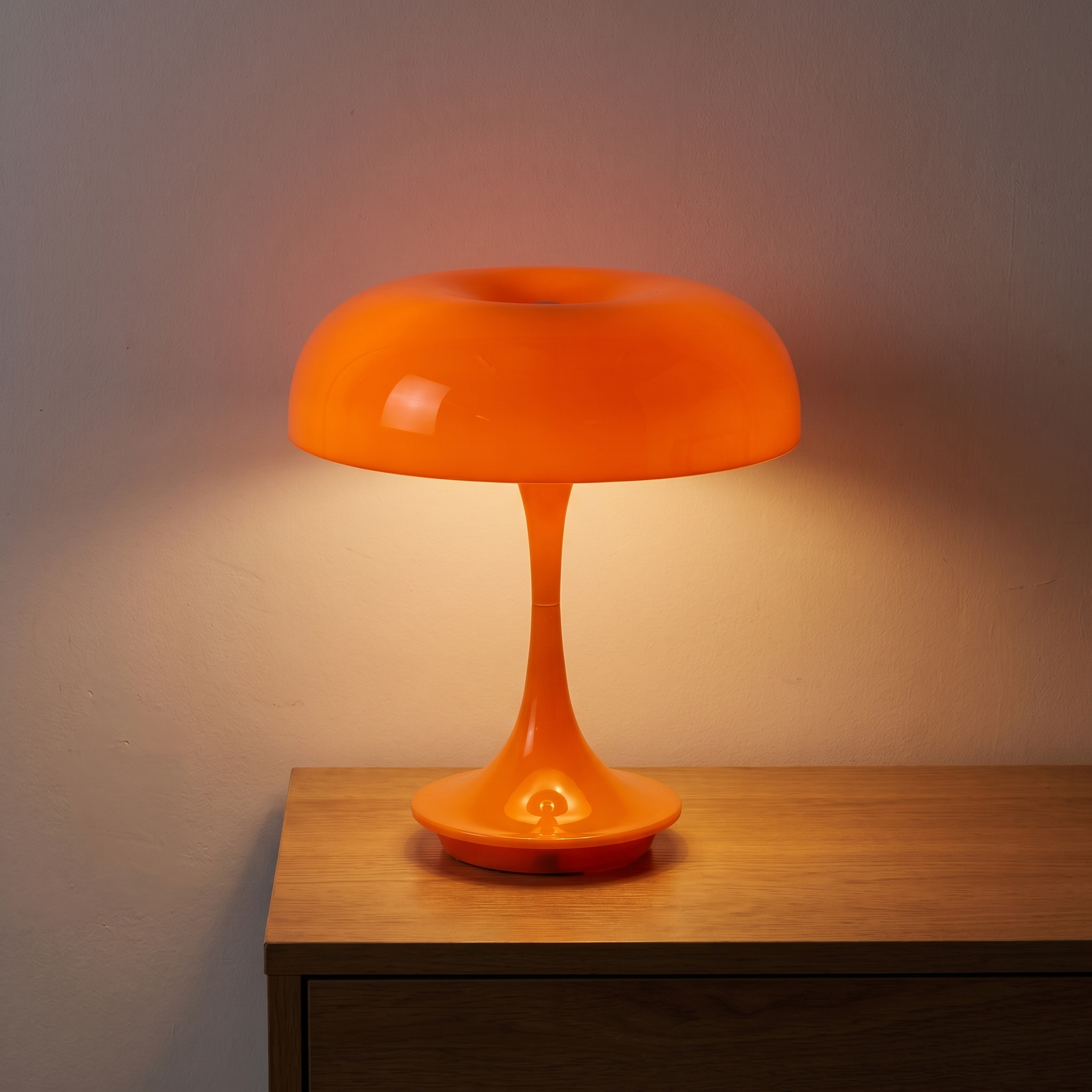 Lámpara Mila naranja encendida en una mesita de noche al anochecer