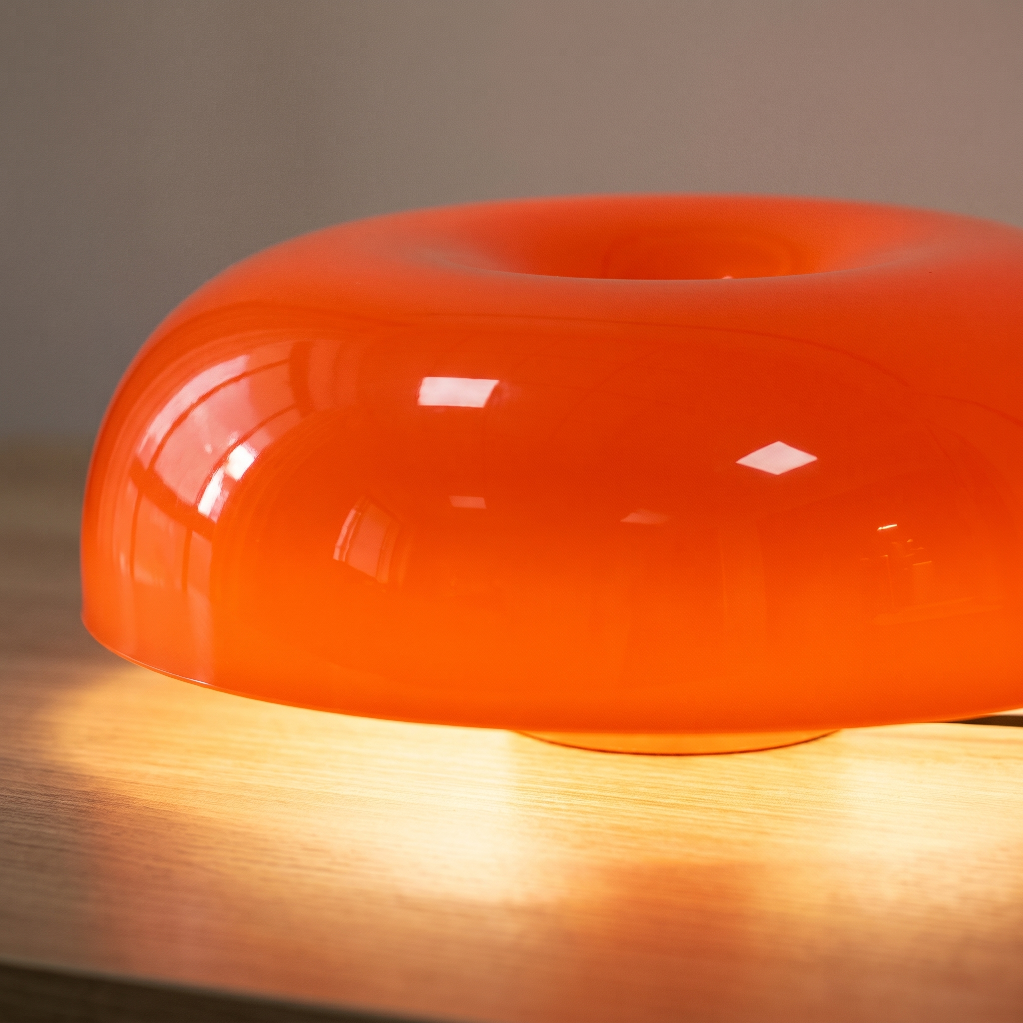 Detalle de la cúpula achatada de plástico brillante naranja de la lámpara Mila