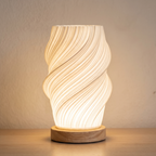 Lámpara de mesa Vela con pantalla en espiral y base de madera natural, encendida