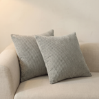 Pareja de cojines de pana gris plata en sofá beige