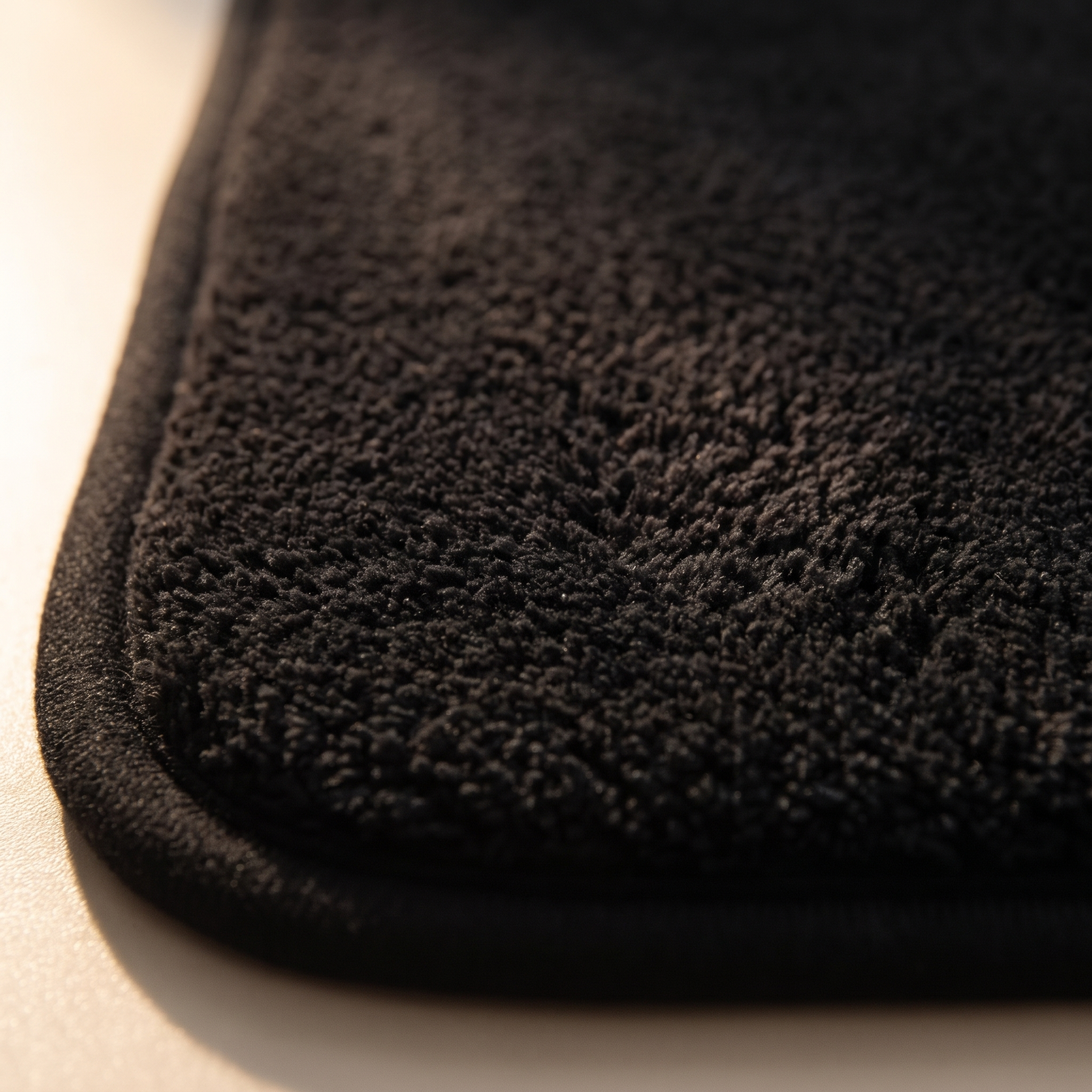 Detalle del pelo denso y el borde de la alfombra de baño negra