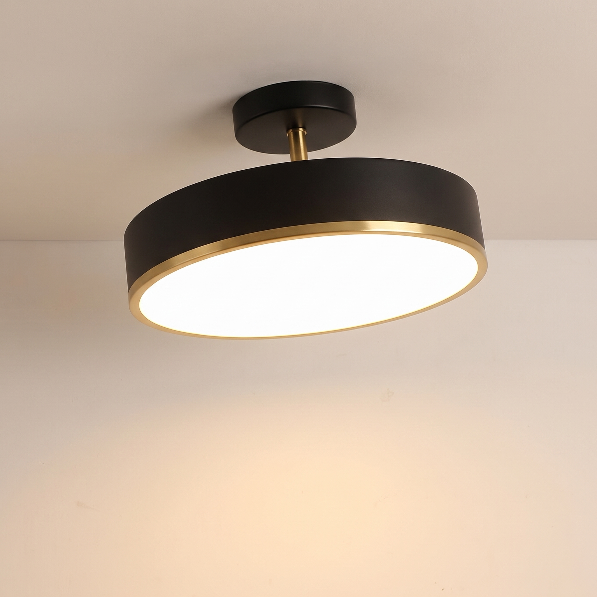 Lámpara de techo LED circular negra y latón encendida en el techo