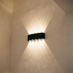 Aplique bidireccional iluminando la pared de una escalera
